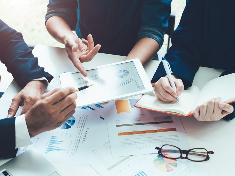 persone mostrano grafici in ufficio con dati sul capitale circolante netto